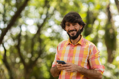 Young man at park on a beautiful sunny day with mobile phone.  working  leisure. green and nature 