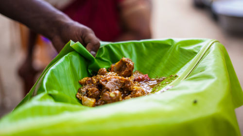 Cropped hand of man holding food