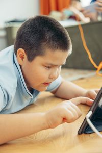 Side view of boy using digital tablet at home