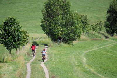 Mother with her son ride a bike in the summer countryside