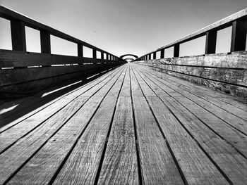 Surface level of footbridge against clear sky