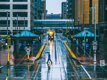 Tram on road along against built structures