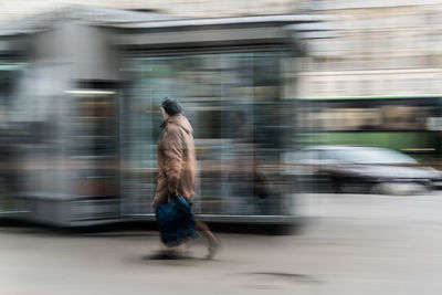 Blurred motion of man walking on road