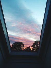 Trees against sky seen through window