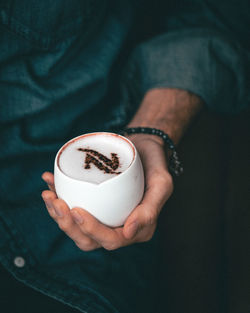 Midsection of man holding coffee cup