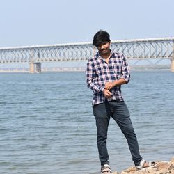 Full length of man standing on bridge against sky