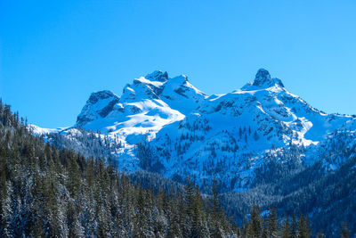 Scenic view of snowcapped mountains against clear blue sky