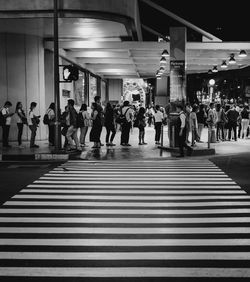 Group of people walking on road in city