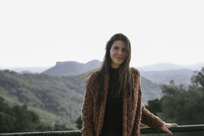 Portrait of young woman against clear sky