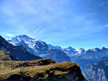 Scenic view of snowcapped mountains against blue sky