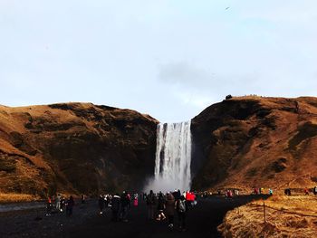 Group of people on rock against the sky