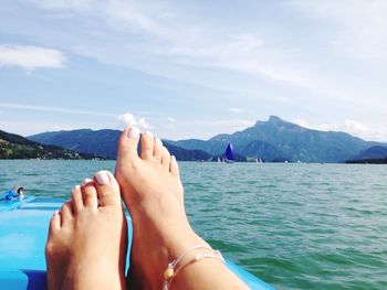 Low section of woman legs against sea