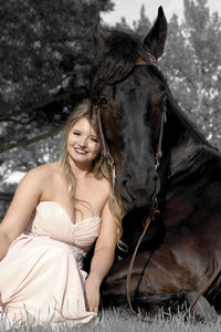 Portrait of teenage girl with horse on field