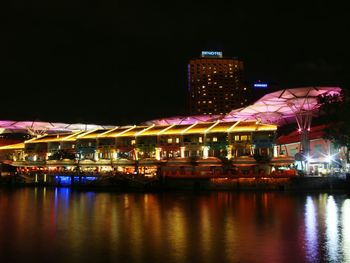 Illuminated bridge over river at night