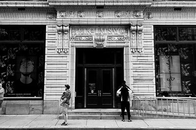 Rear view of woman walking in front of building