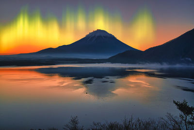 Scenic view of mountains against northern lights sky