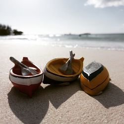 Deck chairs on sand at beach against sky
