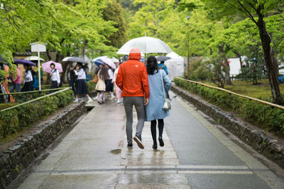 Rear view of couple walking under bridge