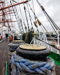 Fishing boat moored at harbor against sky