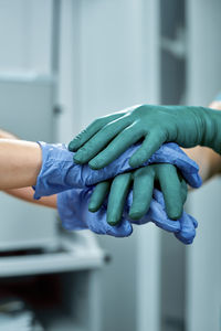 Cropped image of doctors stacking hands at hospital