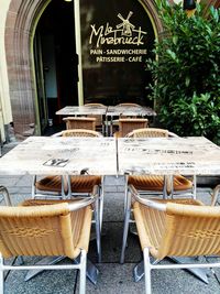 Empty chairs and tables at sidewalk cafe