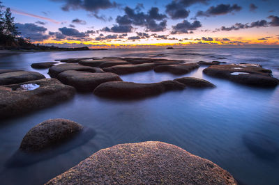 Scenic view of sea against dramatic sky during sunset