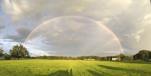 Scenic view of rainbow over landscape against sky