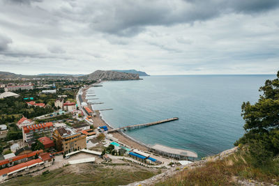 High angle view of townscape by sea against sky