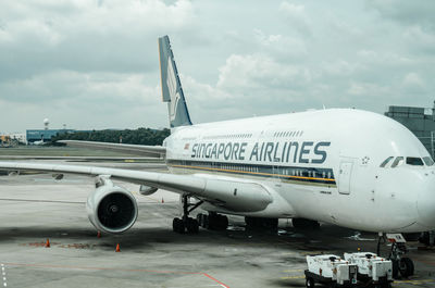 Airplane on airport runway against sky