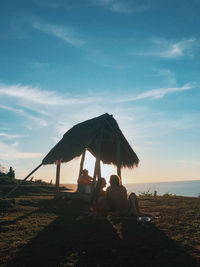 People sitting on land against sky