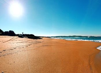 Scenic view of beach against clear blue sky