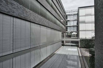 Footpath amidst buildings against sky