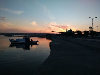 Boats in sea at sunset