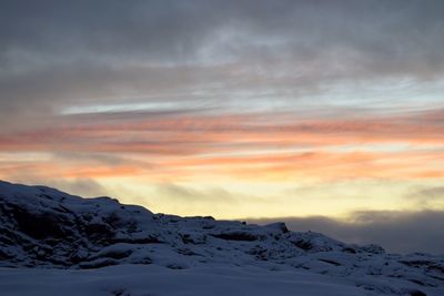 Scenic view of snowcapped mountains against sky during sunset