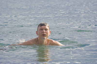 Portrait of mature man swimming in lake