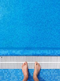 Low section of man standing at poolside