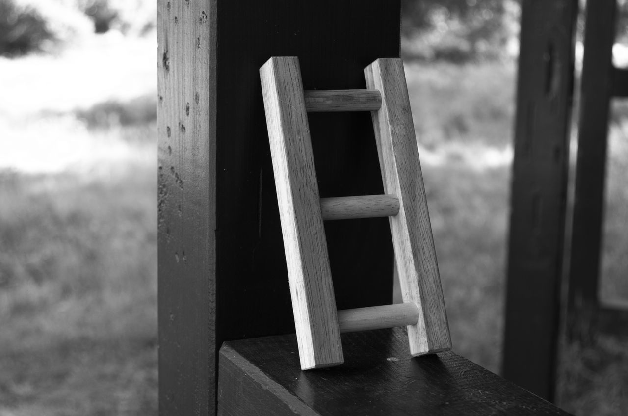 CLOSE-UP OF EMPTY BENCH IN FIELD