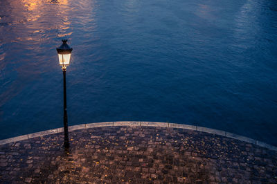 High angle view of illuminated street light by sea