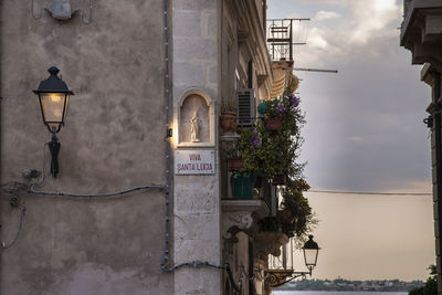 Street light by building against sky