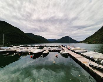 Boats moored in lake against sky