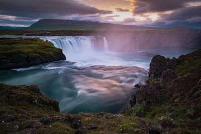 Scenic view of waterfall against sky