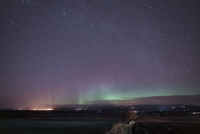 Scenic view of landscape against star field at night