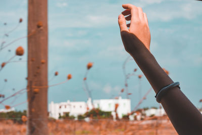 Cropped hand of woman reaching sky