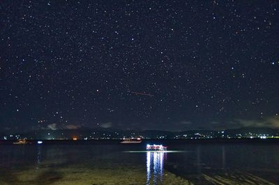 Scenic view of lake against sky at night