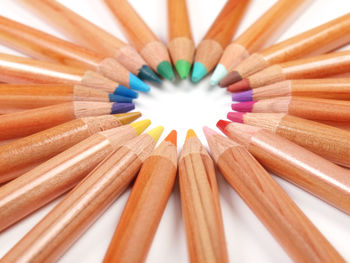 Full frame shot of colored pencils arranged against white background