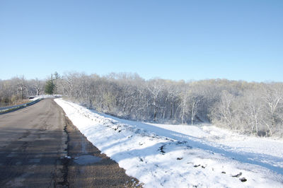 Snow covered road against clear sky