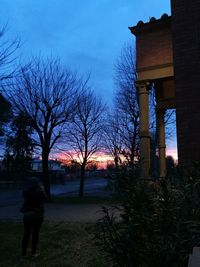 Rear view of silhouette people walking on footpath at dusk