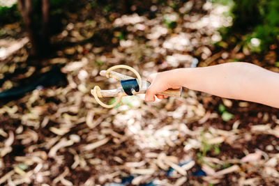 Close-up of hand holding slingshot outdoors