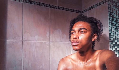 Portrait of shirtless man in bathroom