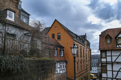 Low angle view of buildings against cloudy sky